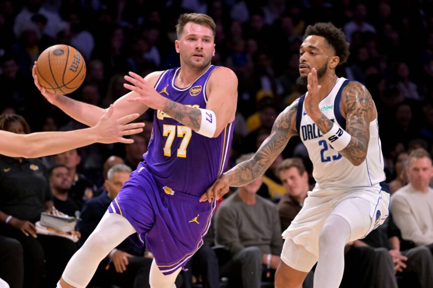 Los Angeles Lakers guard Luka Doncic (77) is defended by Dallas Mavericks forward P.J. Washington (25) as he drives to the basket in the first half at Crypto.com Arena.