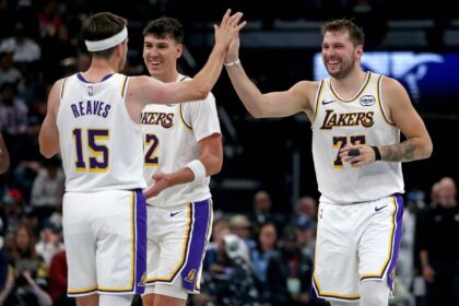 Los Angeles Lakers guard Luka Doncic (77) reacts with guard Austin Reaves (15) during a timeout during the second quarter against the Memphis Grizzlies at FedExForum.