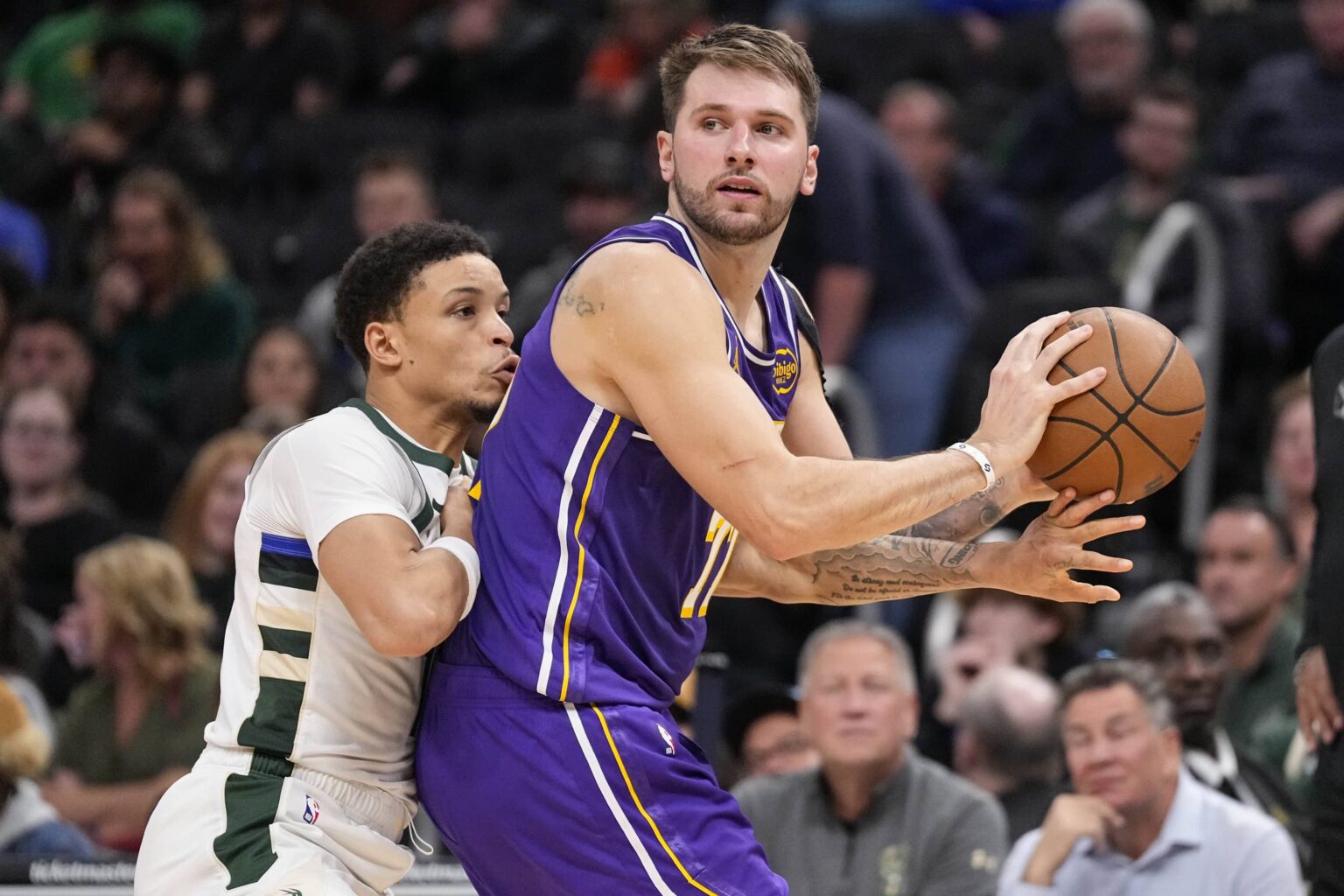 Los Angeles Lakers guard Luka Doncic (77) looks to pass the ball as Milwaukee Bucks guard Ryan Rollins (13) defends during the fourth quarter at Fiserv Forum.