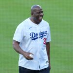 Los Angeles Dodgers co owner Magic Johnson reacts before throwing the ceremonial first pitch before game five of the 2025 MLB World Series between the Toronto Blue Jays and the Los Angeles Dodgers at Dodger Stadium.