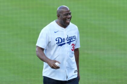 Los Angeles Dodgers co owner Magic Johnson reacts before throwing the ceremonial first pitch before game five of the 2025 MLB World Series between the Toronto Blue Jays and the Los Angeles Dodgers at Dodger Stadium.