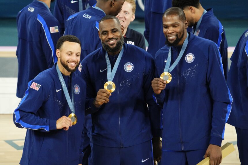 Aug 10, 2024; Paris, France; United States shooting guard Stephen Curry (4) and guard LeBron James (6) and guard Kevin Durant (7) celebrate with their gold medals on the podium after defeating France in the men's basketball gold medal game during the Paris 2024 Olympic Summer Games at Accor Arena. Mandatory Credit: Rob Schumacher-USA TODAY Sports
