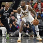 San Antonio, Texas, USA; Los Angeles Lakers forward LeBron James (23) looks to pass the ball while defended by San Antonio Spurs guard Chris Paul (3) during the first half during the first half at Frost Bank Center. Mandatory Credit: Scott Wachter-Imagn Images