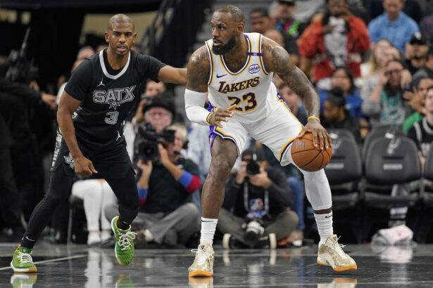 San Antonio, Texas, USA; Los Angeles Lakers forward LeBron James (23) looks to pass the ball while defended by San Antonio Spurs guard Chris Paul (3) during the first half during the first half at Frost Bank Center. Mandatory Credit: Scott Wachter-Imagn Images