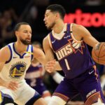 Apr 8, 2025; Phoenix, Arizona, USA; Phoenix Suns guard Devin Booker (1) dribbles the ball agisasnt Golden State Warriors guard Stephen Curry (30) during the first half at Footprint Center. Mandatory Credit: Mark J. Rebilas-Imagn Images