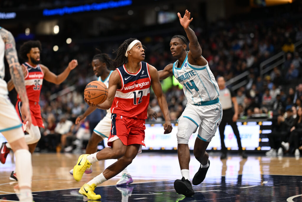 Oct 26, 2025; Washington, District of Columbia, USA; Washington Wizards guard Tre Johnson (12) drives the basket in front to Charlotte Hornets forward Moussa Diabate (14) during the first quarter at Capital One Arena. Mandatory Credit: Rafael Suanes-Imagn Images
