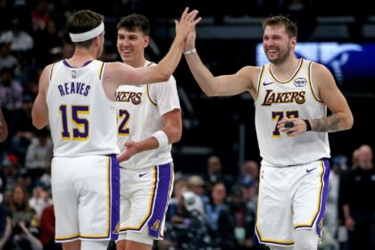 Oct 31, 2025; Memphis, Tennessee, USA; Los Angeles Lakers guard Luka Doncic (77) reacts with guard Austin Reaves (15) during a timeout during the second quarter against the Memphis Grizzlies at FedExForum. Mandatory Credit: Petre Thomas-Imagn Images