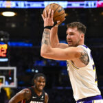 Nov 2, 2025; Los Angeles, California, USA; Los Angeles Lakers guard Luka Doncic (77) looks to pass the ball against Miami Heat guard Davion Mitchell (45) during the first half at Crypto.com Arena. Mandatory Credit: Jonathan Hui-Imagn Images