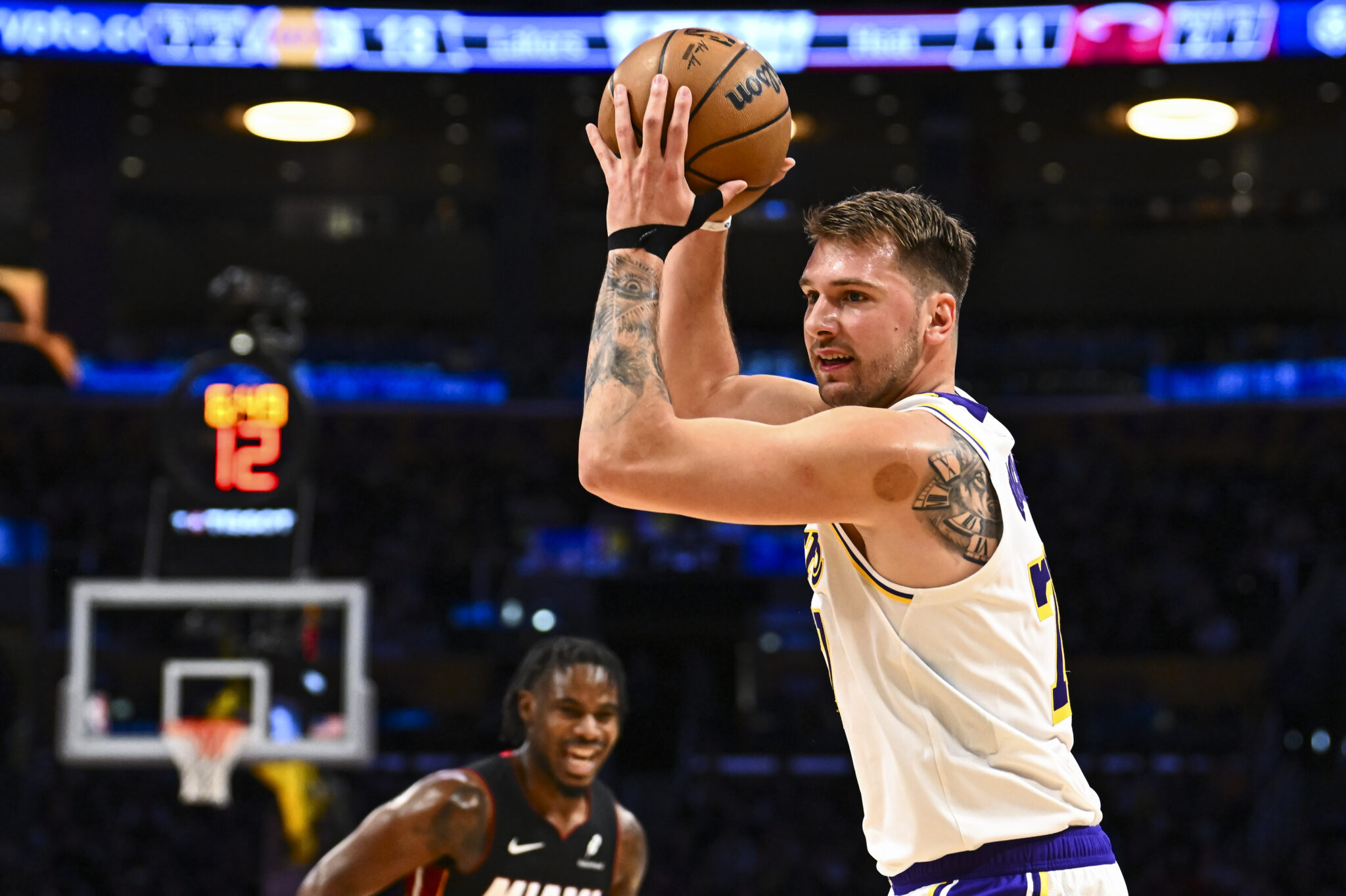 Nov 2, 2025; Los Angeles, California, USA; Los Angeles Lakers guard Luka Doncic (77) looks to pass the ball against Miami Heat guard Davion Mitchell (45) during the first half at Crypto.com Arena. Mandatory Credit: Jonathan Hui-Imagn Images
