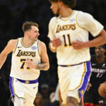 Nov 2, 2025; Los Angeles, California, USA; Los Angeles Lakers guard Luka Dončić (77) runs down the court with center Jaxson Hayes (11) against Miami Heat center/forward Bam Adebayo (13) during the first half at Crypto.com Arena. Mandatory Credit: Jonathan Hui-Imagn Images