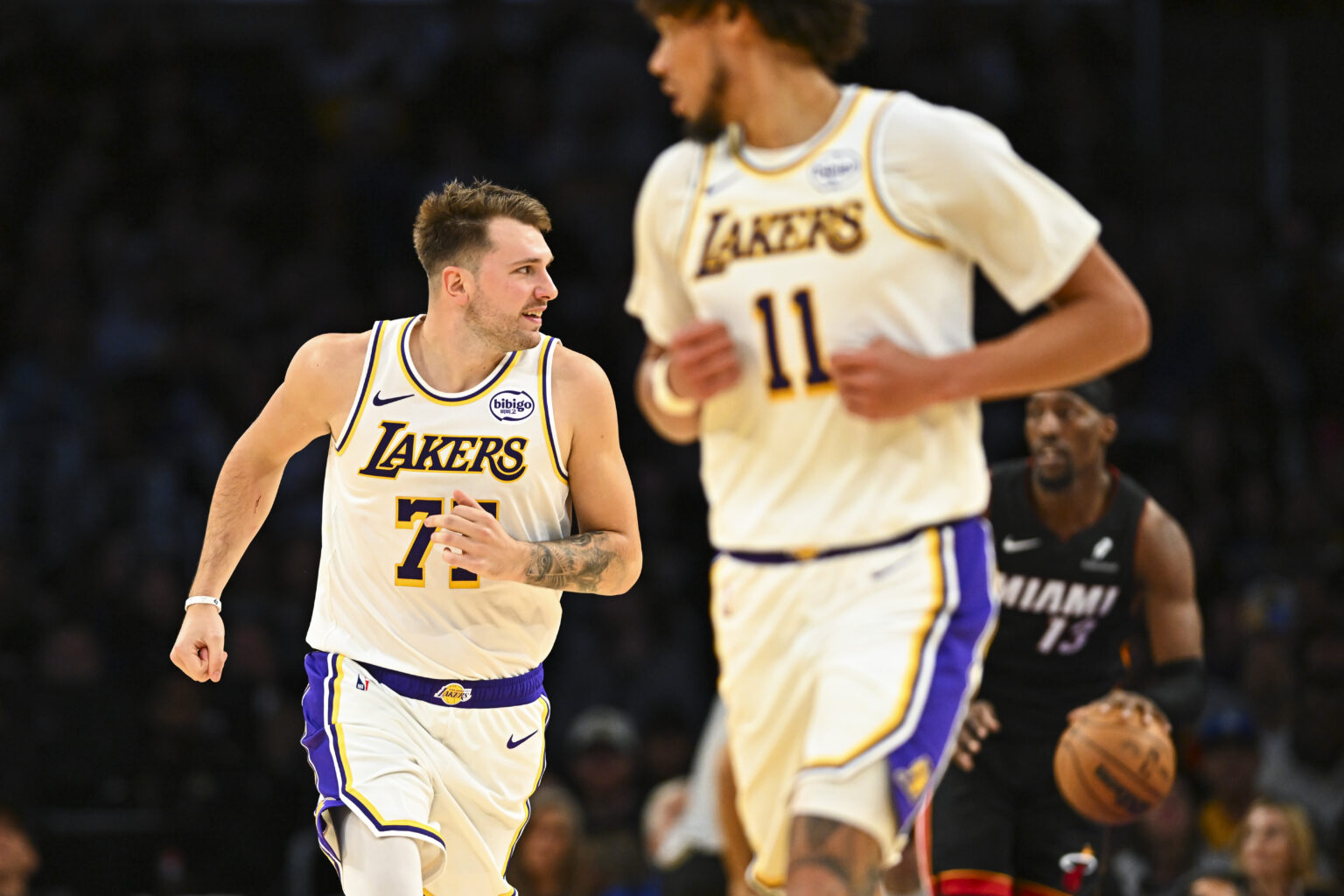Nov 2, 2025; Los Angeles, California, USA; Los Angeles Lakers guard Luka Dončić (77) runs down the court with center Jaxson Hayes (11) against Miami Heat center/forward Bam Adebayo (13) during the first half at Crypto.com Arena. Mandatory Credit: Jonathan Hui-Imagn Images