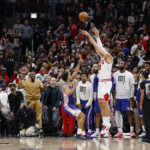 Nov 4, 2025; Chicago, Illinois, USA; Chicago Bulls center Nikola Vucevic (9) shoots and scores a game winning three-pointer against Philadelphia 76ers guard Quentin Grimes (5) during the second half at United Center. Mandatory Credit: Kamil Krzaczynski-Imagn Images