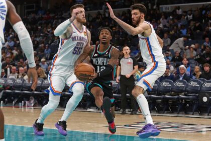 Nov 9, 2025; Memphis, Tennessee, USA; Memphis Grizzlies guard Ja Morant (12) drives to the basket between Oklahoma City Thunder center Isaiah Hartenstein (55) and center Chet Holmgren (7) during the third quarter at FedExForum. Mandatory Credit: Petre Thomas-Imagn Images