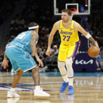 Nov 10, 2025; Charlotte, North Carolina, USA; Los Angeles Lakers forward/guard Luka Doncic (77) is guarded by Charlotte Hornets guard Tre Mann (23) during the second quarter at Spectrum Center. Mandatory Credit: Brian Westerholt-Imagn Images
