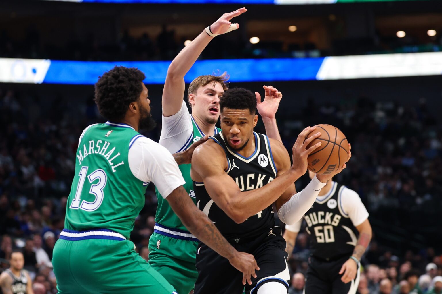 Nov 10, 2025; Dallas, Texas, USA; Milwaukee Bucks forward Giannis Antetokounmpo (34) controls the ball as Dallas Mavericks forward Cooper Flagg (32) and Dallas Mavericks forward Naji Marshall (13) defend during the first quarter at American Airlines Center. Mandatory Credit: Kevin Jairaj-Imagn Images