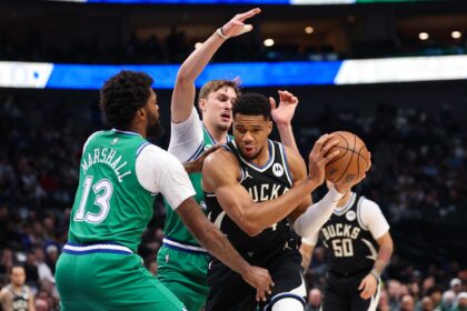 Nov 10, 2025; Dallas, Texas, USA; Milwaukee Bucks forward Giannis Antetokounmpo (34) controls the ball as Dallas Mavericks forward Cooper Flagg (32) and Dallas Mavericks forward Naji Marshall (13) defend during the first quarter at American Airlines Center. Mandatory Credit: Kevin Jairaj-Imagn Images