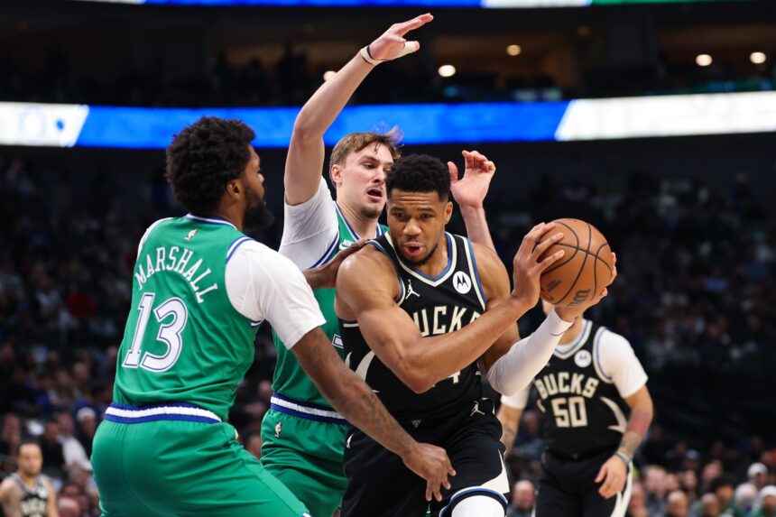 Nov 10, 2025; Dallas, Texas, USA; Milwaukee Bucks forward Giannis Antetokounmpo (34) controls the ball as Dallas Mavericks forward Cooper Flagg (32) and Dallas Mavericks forward Naji Marshall (13) defend during the first quarter at American Airlines Center. Mandatory Credit: Kevin Jairaj-Imagn Images