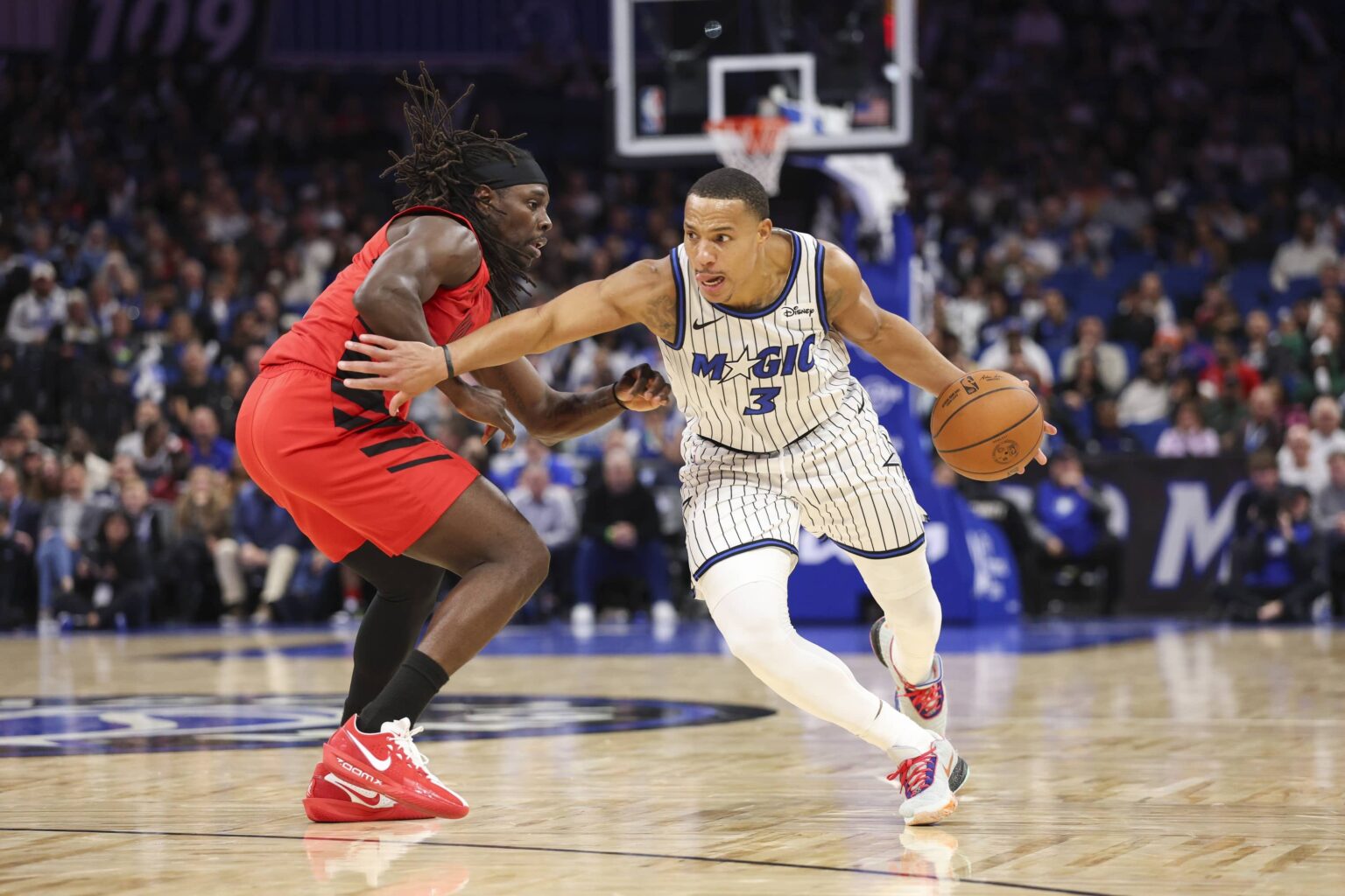 Nov 10, 2025; Orlando, Florida, USA; Orlando Magic guard Desmond Bane (3) drives the ball past Portland Trail Blazers guard Jrue Holiday (5) in the fourth quarter at Kia Center. Mandatory Credit: Nathan Ray Seebeck-Imagn Images