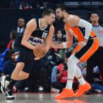 Nov 12, 2025; Inglewood, California, USA; Denver Nuggets center Nikola Jokic (15) moves the ball against Los Angeles Clippers center Ivica Zubac (40) during the first half at Intuit Dome. Mandatory Credit: Gary A. Vasquez-Imagn Images