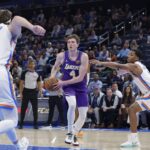 Nov 12, 2025; Oklahoma City, Oklahoma, USA; Los Angeles Lakers forward Dalton Knecht (4) drives to the basket between Oklahoma City Thunder center Branden Carlson (15) and guard Chris Youngblood (3) during the fourth quarter at Paycom Center. Mandatory Credit: Alonzo Adams-Imagn Images