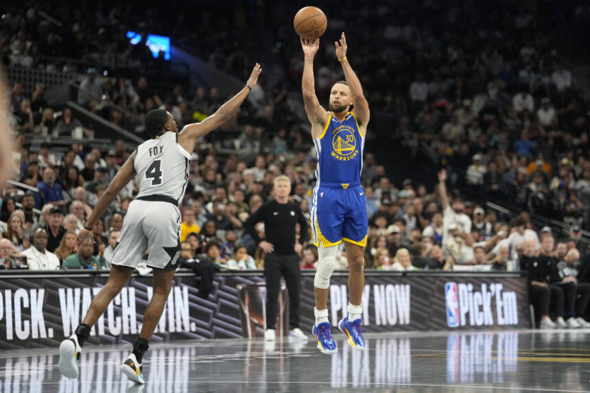 Nov 14, 2025; San Antonio, Texas, USA; Golden State Warriors guard Stephen Curry (30) shoots over San Antonio Spurs 04 guard DeAaron Fox (4) during the first half at Frost Bank Center. Mandatory Credit: Scott Wachter-Imagn Images