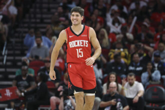 Nov 16, 2025; Houston, Texas, USA; Houston Rockets guard Reed Sheppard (15) smiles after a play during the second quarter against the Orlando Magic at Toyota Center. Mandatory Credit: Troy Taormina-Imagn Images