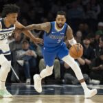 Dallas Mavericks guard D'Angelo Russell (5) dribbles the ball past Minnesota Timberwolves guard Jaylen Clark (22) in the first half at Target Center.