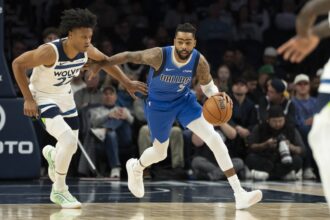 Dallas Mavericks guard D'Angelo Russell (5) dribbles the ball past Minnesota Timberwolves guard Jaylen Clark (22) in the first half at Target Center.