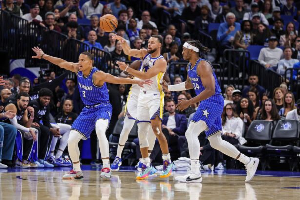 Nov 18, 2025; Orlando, Florida, USA; Golden State Warriors guard Stephen Curry (30) passes the ball over Orlando Magic guard Desmond Bane (3) during the first quarter at Kia Center. Mandatory Credit: Mike Watters-Imagn Images