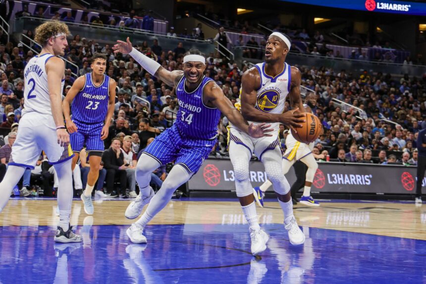 Nov 18, 2025; Orlando, Florida, USA; Golden State Warriors forward Jimmy Butler III (10) looks to shoot against Orlando Magic center Wendell Carter Jr. (34) during the second half at Kia Center. Mandatory Credit: Mike Watters-Imagn Images