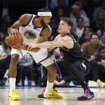 Nov 19, 2025; Miami, Florida, USA; Miami Heat guard Pelle Larsson (9) defends against Golden State Warriors guard Moses Moody (4) during the second half at Kaseya Center. Mandatory Credit: Rhona Wise-Imagn Images