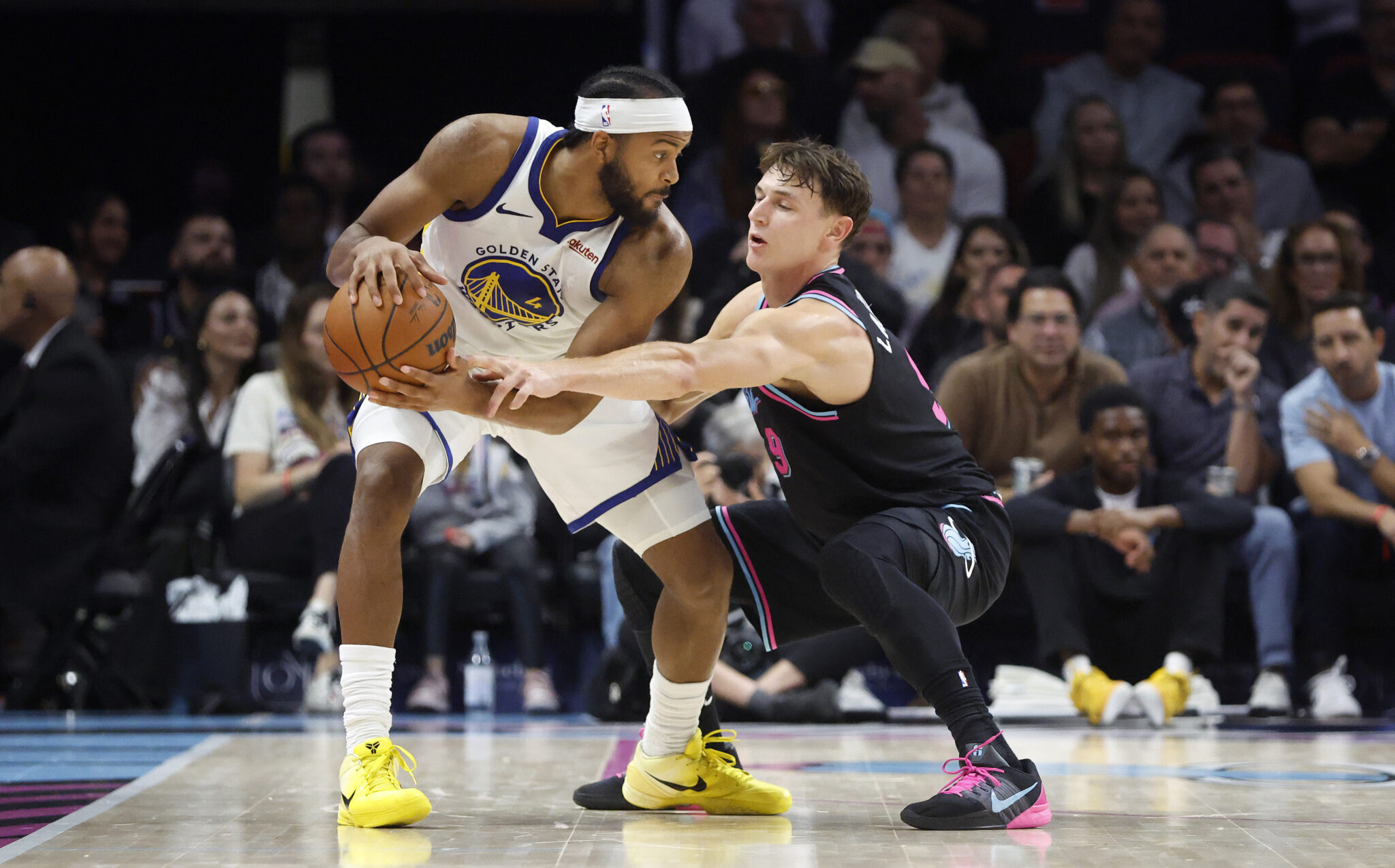 Nov 19, 2025; Miami, Florida, USA; Miami Heat guard Pelle Larsson (9) defends against Golden State Warriors guard Moses Moody (4) during the second half at Kaseya Center. Mandatory Credit: Rhona Wise-Imagn Images