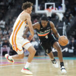 Nov 20, 2025; San Antonio, Texas, USA; San Antonio Spurs guard De’Aaron Fox (4) drives to the basket against Atlanta Hawks guard Dyson Daniels (5) during the first half at Frost Bank Center. Mandatory Credit: Scott Wachter-Imagn Images