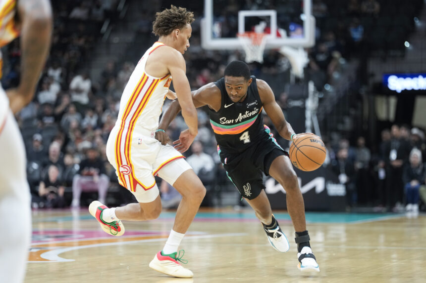 Nov 20, 2025; San Antonio, Texas, USA; San Antonio Spurs guard De’Aaron Fox (4) drives to the basket against Atlanta Hawks guard Dyson Daniels (5) during the first half at Frost Bank Center. Mandatory Credit: Scott Wachter-Imagn Images