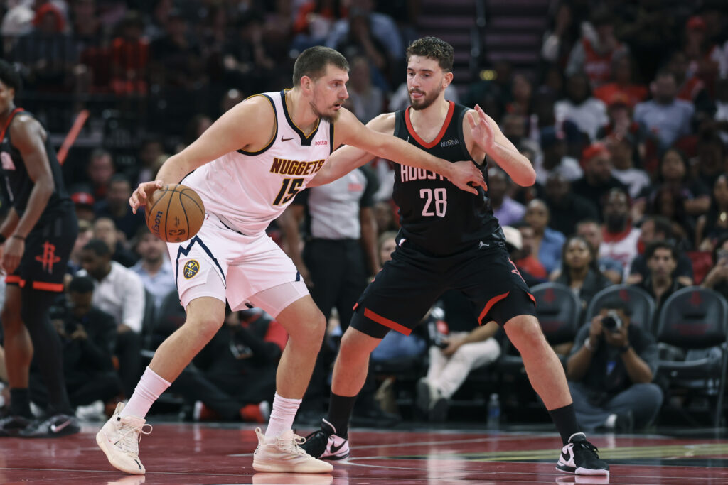 Nov 21, 2025; Houston, Texas, USA; Denver Nuggets center Nikola Jokic (15) controls the ball as Houston Rockets center Alperen Sengun (28) defends during the second quarter at Toyota Center. Mandatory Credit: Troy Taormina-Imagn Images