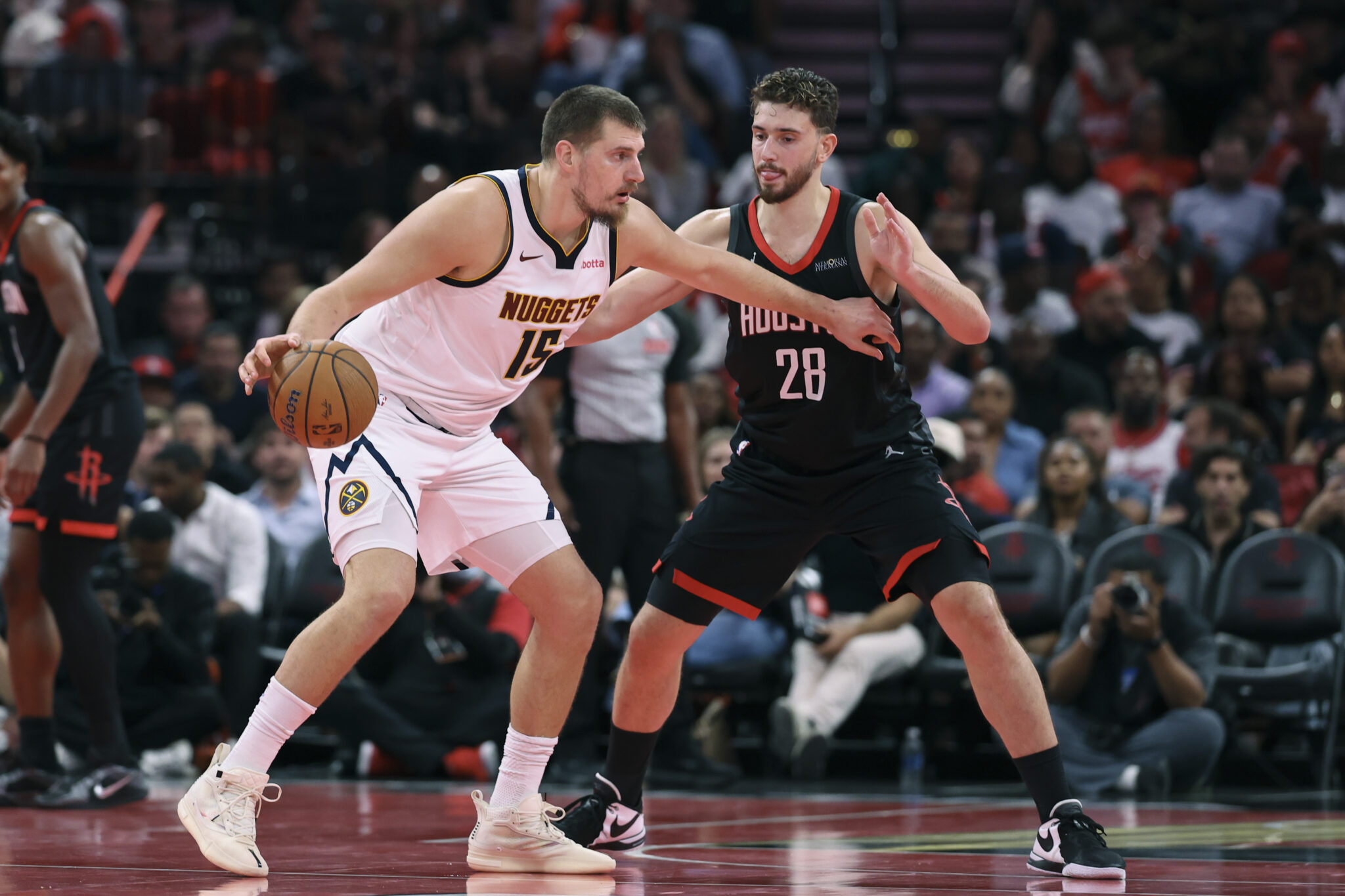 Nov 21, 2025; Houston, Texas, USA; Denver Nuggets center Nikola Jokic (15) controls the ball as Houston Rockets center Alperen Sengun (28) defends during the second quarter at Toyota Center. Mandatory Credit: Troy Taormina-Imagn Images