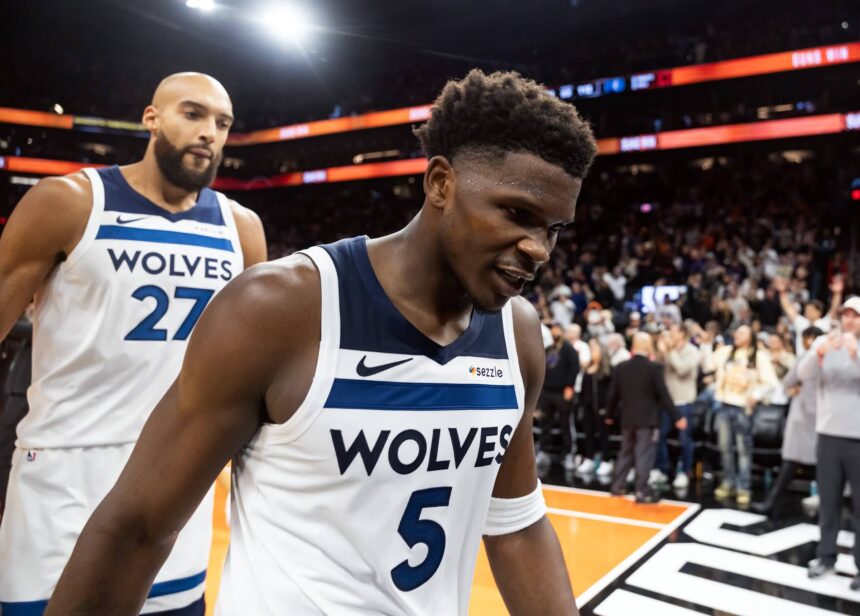 Nov 21, 2025; Phoenix, Arizona, USA; Minnesota Timberwolves guard Anthony Edwards (5) and center Rudy Gobert (27) react as they walk off the court after losing to the Phoenix Suns in the second half of an NBA Cup game at Mortgage Matchup Center. Mandatory Credit: Mark J. Rebilas-Imagn Images