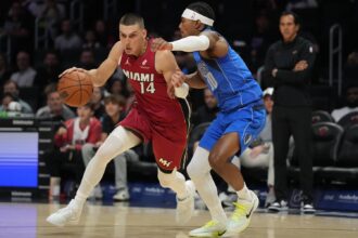 Nov 24, 2025; Miami, Florida, USA; Miami Heat guard Tyler Herro (14) drives to the basket as Dallas Mavericks guard Brandon Williams (10) defends during the first half at Kaseya Center. Mandatory Credit: Jim Rassol-Imagn Images
