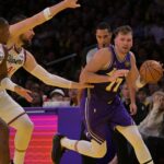 Nov 25, 2025; Los Angeles, California, USA; Los Angeles Lakers guard Luka Doncic (77) drives past Los Angeles Clippers guard Kris Dunn (8) and center Ivica Zubac (40) during the first half at Crypto.com Arena. Mandatory Credit: Jayne Kamin-Oncea-Imagn Images