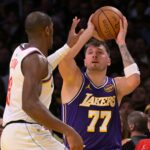 Nov 25, 2025; Los Angeles, California, USA; Los Angeles Lakers guard Luka Doncic (77) is defended by Los Angeles Clippers guard Kris Dunn (8) during the first half at Crypto.com Arena. Mandatory Credit: Jayne Kamin-Oncea-Imagn Images