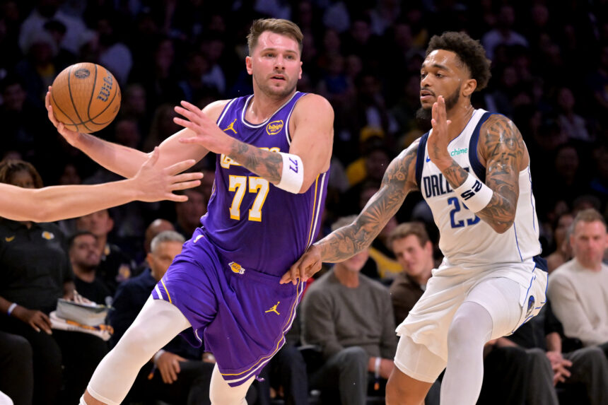 Nov 28, 2025; Los Angeles, California, USA; Los Angeles Lakers guard Luka Doncic (77) is defended by Dallas Mavericks forward P.J. Washington (25) as he drives to the basket in the first half at Crypto.com Arena. Mandatory Credit: Jayne Kamin-Oncea-Imagn Images
