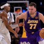 Nov 28, 2025; Los Angeles, California, USA; Los Angeles Lakers guard Luka Doncic (77) is defended by Dallas Mavericks guard Brandon Williams (10) as he drives to the basket in the first half at Crypto.com Arena. Mandatory Credit: Jayne Kamin-Oncea-Imagn Images