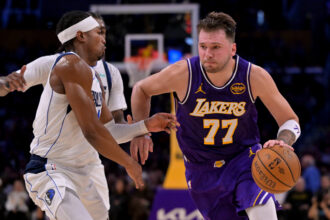 Nov 28, 2025; Los Angeles, California, USA; Los Angeles Lakers guard Luka Doncic (77) is defended by Dallas Mavericks guard Brandon Williams (10) as he drives to the basket in the first half at Crypto.com Arena. Mandatory Credit: Jayne Kamin-Oncea-Imagn Images