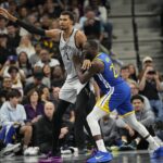 San Antonio Spurs forward Victor Wembanyama (1) posts up on Golden State Warriors forward Draymond Green (23) during the first half at Frost Bank Center.