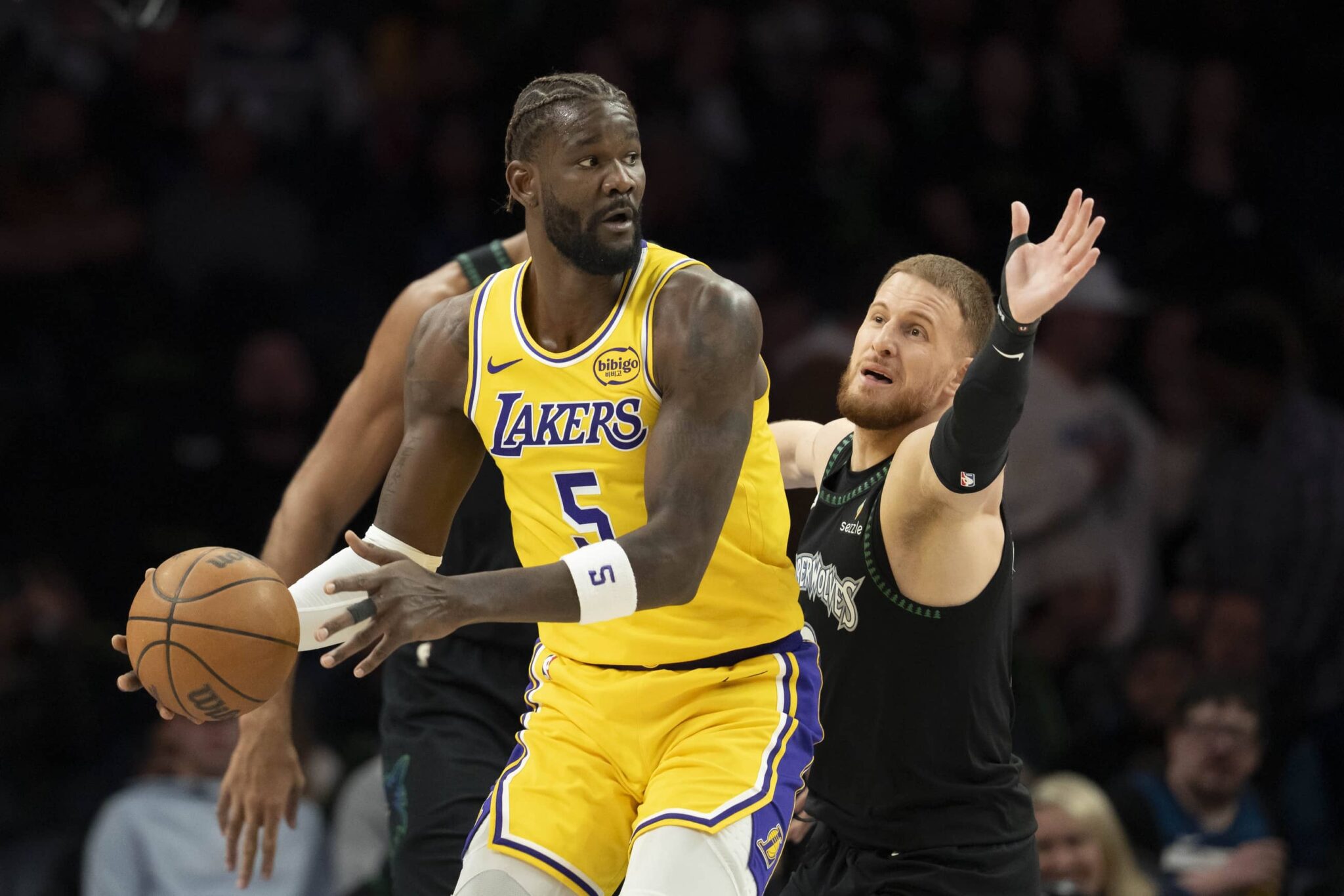 Minneapolis, Minnesota, USA; Los Angeles Lakers center Deandre Ayton (5) looks to pass the ball as Minnesota Timberwolves guard Donte DiVincenzo (0) plays defense in the first half at Target Center. Mandatory Credit: Jesse Johnson-Imagn Images