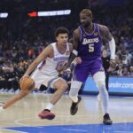 Oklahoma City, Oklahoma, USA; Oklahoma City Thunder forward Ousmane Dieng (13) drives to the basket beside Los Angeles Lakers center Deandre Ayton (5) during the second quarter at Paycom Center. Mandatory Credit: Alonzo Adams-Imagn Images