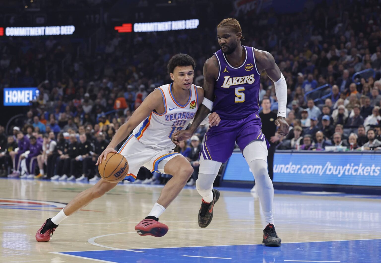 Oklahoma City, Oklahoma, USA; Oklahoma City Thunder forward Ousmane Dieng (13) drives to the basket beside Los Angeles Lakers center Deandre Ayton (5) during the second quarter at Paycom Center. Mandatory Credit: Alonzo Adams-Imagn Images