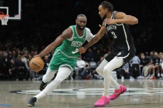 Brooklyn, New York, USA; Boston Celtics guard Jaylen Brown (7) brings the ball up court against Brooklyn Nets center Nic Claxton (33) during the second quarter at Barclays Center. Mandatory Credit: Brad Penner-Imagn Images