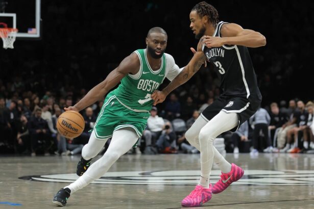 Brooklyn, New York, USA; Boston Celtics guard Jaylen Brown (7) brings the ball up court against Brooklyn Nets center Nic Claxton (33) during the second quarter at Barclays Center. Mandatory Credit: Brad Penner-Imagn Images