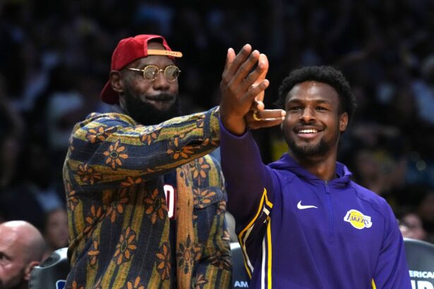 Los Angeles, California, USA; Los Angeles Lakers forward LeBron James (left) and son Bronny James watch from the bench in the second half against the Minnesota Timberwolves at Crypto.com Arena. Mandatory Credit: Kirby Lee-Imagn Images